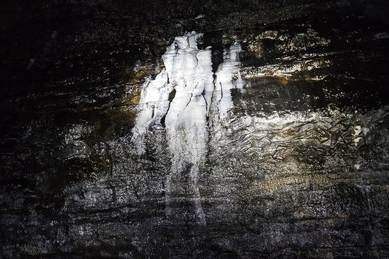 김녕굴 내부 벽의 흰색 얼룩. 박테리아가 굳어 형성됐다는데 꼭 사람이 서 있는 것 같다.