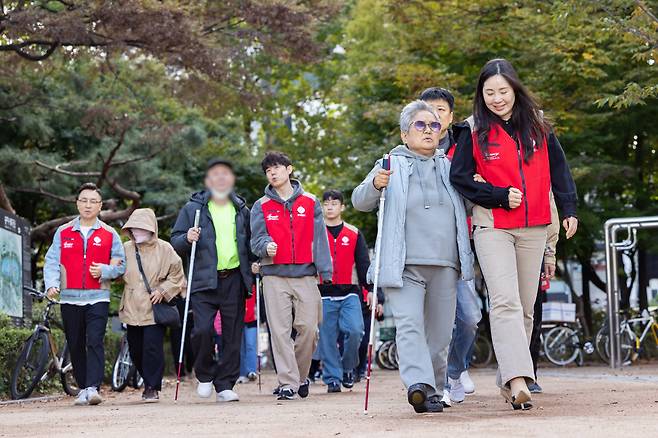 롯데월드 샤롯데 봉사단이 시각장애인 당사자들과 함께 걸으며 봉사활동을 하고 있다.