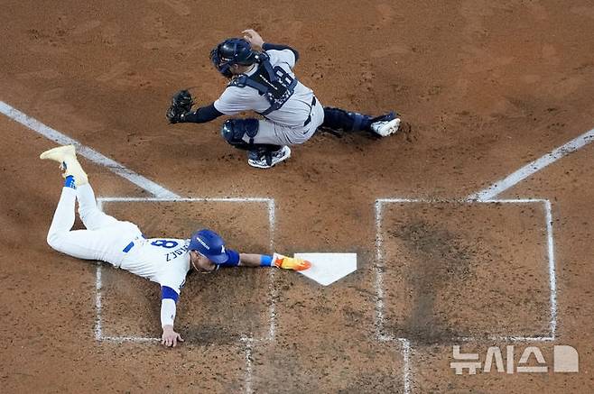 [로스앤젤레스=AP/뉴시스] 미국 캘리포니아주 로스앤젤레스 다저스타디움에서 벌어진 뉴욕 양키스와 LA 다저스의 월드시리즈 1차전, 5회 LA 다저스 엔리케 에르난데스가 윌 스미스의 희생플라이에 홈인해 득점을 올리고 있다. 2024.10.26.