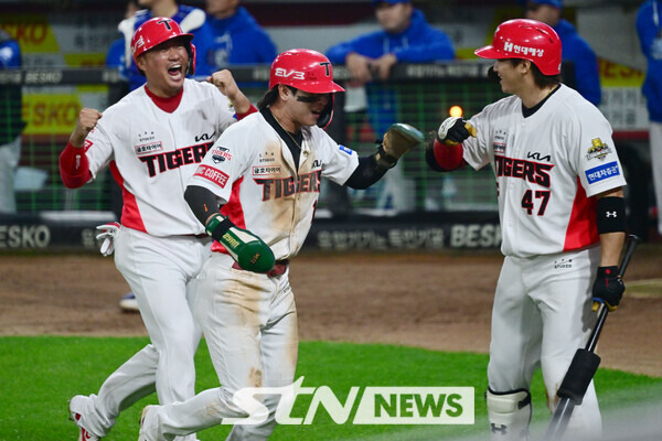 28일 광주 북구 광주-기아챔피언스필드에서 열린 2024 KBO 포스트시즌 한국시리즈 5차전 삼성 라이온즈와 KIA 타이거즈의 경기, 5회 말 2사 만루 상황에서 삼성 김윤수의 폭투에 홈인해 득점한 KIA 박찬호와 김태군이 기뻐하며 덕아웃으로 들어가고 있다. 사진┃뉴시스