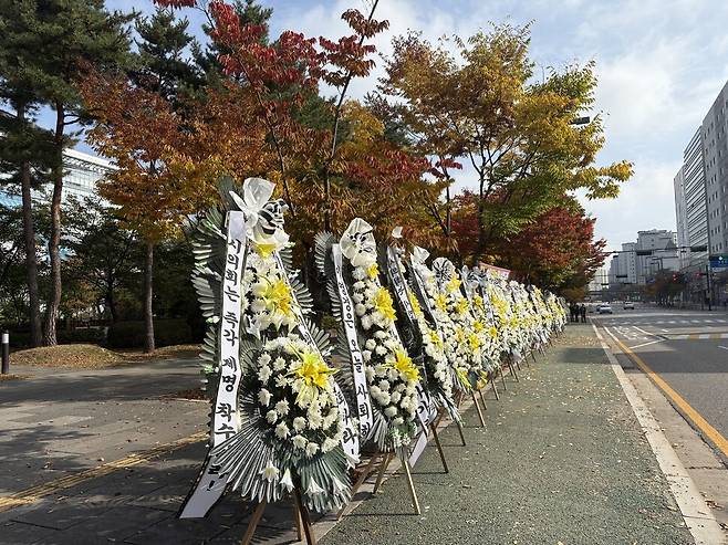 28일 오전 경기도 성남시의회 청사 정문 앞 인도에 학교 폭력에 가담한 자녀를 둔 시의원의 사퇴와 제명을 촉구하는 근조화환이 늘어서 있다. 김기성 기자