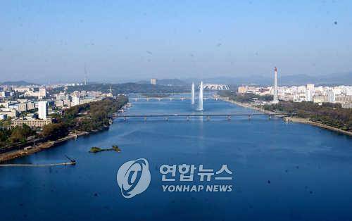 대동강 가르는 평양 넓고 평평한 지역이라서 평양으로 불렸다는 북한의 수도, 인구 200만 북한 정치.경제.사회.문화의 중심지 평양은 보통강이 시내를 휘감아 돌아 대동강 본류와 합류하는 전형적인 대도시 모습이다. 양각도에서 바라본 전경은 멀리 대동교(앞쪽)와 옥류교 너머 능라도 경기장이 보인다. 김일성광장(왼쪽)과 주체사상탑을 사이로 양교 사이에서 뿜어대는 대형 분수대는 이곳이 마치 서울인 양 착각을 갖게한다. /김병만/북한/ 2003.10.21 (서울=연합뉴스) kimb01@yna.co.kr