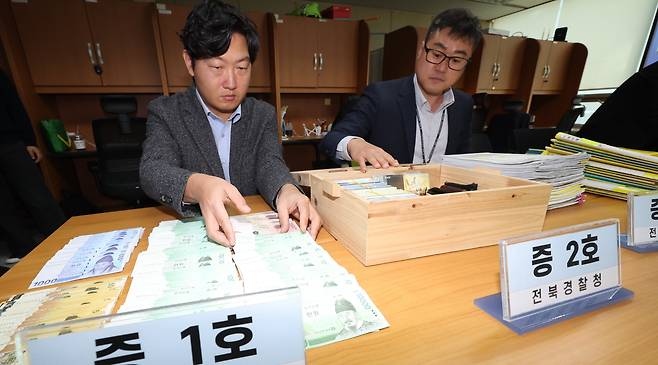 전북경찰청 반부패경제범죄수사대가 30일 전북 전주시 전북경찰청 브리핑룸에서 전세사기 피의자 검거 브리핑을 열고 압수한 증거품을 정리하고 있다./뉴시스