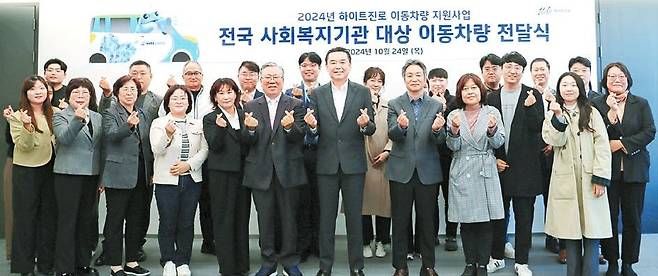 지난 24일 하이트진로 김인규 대표(앞줄 오른쪽 넷째)와 사회복지기관 대표 및 관계자가 참석한 가운데 이동차량 전달식이 진행됐다. [사진 하이트진로]