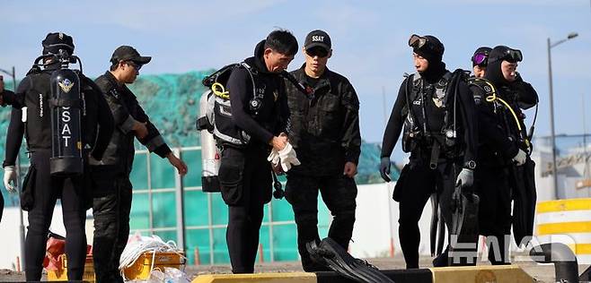 [제주=뉴시스] (왼쪽 세 번째)박상춘 제주해경청장이 30일 오후 제주시 애월항에서 수중 정화활동을 위해 다이버들과 입수 준비를 하고 있다. (사진=제주해경청 제공) 2024.10.30. photo@newsis.com