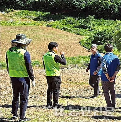 경기 연천 임진농협 현상태 조합장(왼쪽 세번째)이 ‘함께나눔봉사단’ 회원들과 함께 최전방에 있는 경사진 콩밭을 찾아 일손지원에 관한 이야기를 나누고 있다.