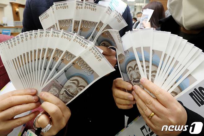 지류형 온누리상품권을 소비자들이 펼쳐보이고 있다. 사용 기록 등이 투명하게 관리되는 디지털 온누리상품권과 달리 '지류형' 상품권은 부정유통 의혹이 적지 않다. /뉴스1 ⓒ News1 공정식 기자