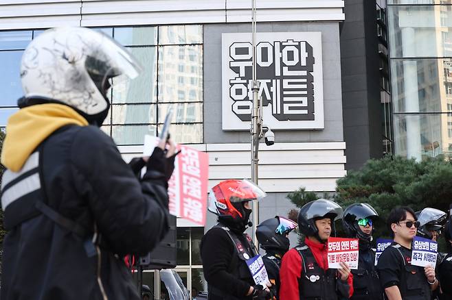 배달 플랫폼-입점 업체 상생협의체 9차 회의가 열리는 30일 오후 서울 송파구 우아한형제들 본사 앞에서 라이더유니온 주최로 열린 기본 배달운임 인상 촉구 기자회견에서 한 배달 기사가 현장을 촬영하고 있다. /연합뉴스