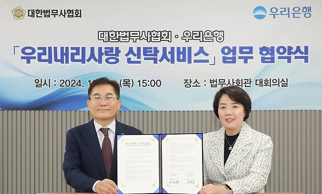 우리은행은 지난 31일 서울 강남구 소재 대한법무사회관에서 우리내리사랑 신탁서비스 업무협약을 체결했다고 1일 밝혔다. 우리은행 송현주 자산관리그룹장(오른쪽)과 대한법무사협회 이강천 협회장이 기념촬영을 하는 모습. (우리은행 제공)