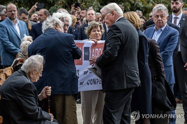 (AFP=연합뉴스) 31일(현지시간) 그리스 크레타섬의 민간인 학살 장소를 찾아 사죄한 프랑크발터 슈타인마이어 독일 대통령 앞에서 배상금 문제를 제기하는 희생자 유족들. 2024.10.31