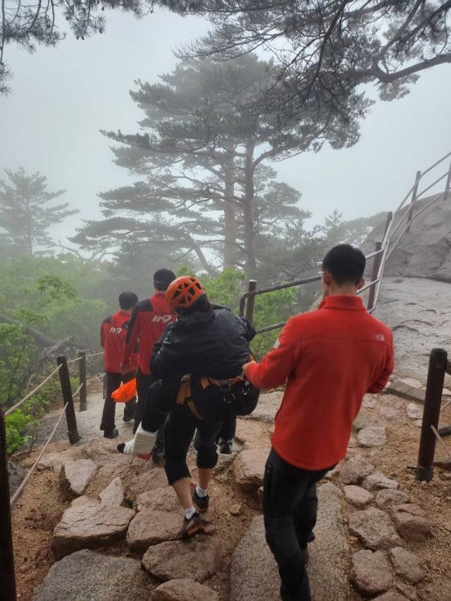 지난 4월 설악산 울산바위에서 발목 다친 20대 이스라엘 여성을 응급조치한 뒤 업고 내려오는 119 대원들. 10월에는 같은 길에서 스웨덴 여성을 구조했다. /강원소방본부