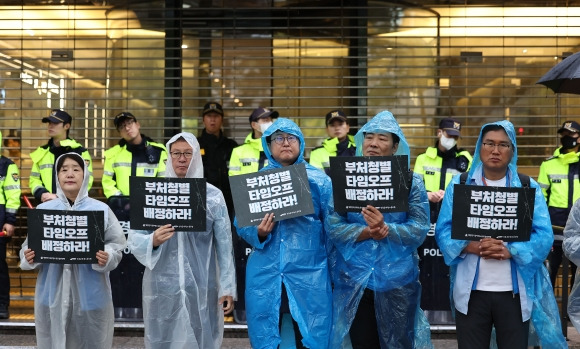 지난달 22일 오전 공무원 근무시간면제 심의위원회 11차 전원회의가 열린 서울 종로구 경제사회노동위원회 앞에서 대한민국공무원노동조합총연맹, 전국공무원노동조합 조합원들이 논의 중인 타임오프 한도 범위에 대해 비판하며 관련 팻말을 들고 있다. 연합뉴스