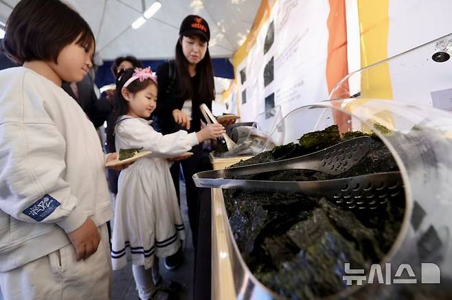 [서울=뉴시스] 김명년 기자 = 3일 오전 서울 영등포구 여의도한강공원 이벤트광장에서 열린 ‘전남 세계 김밥 페스티벌’에서 아이들이 김을 고르고 있다. 2024.11.03. kmn@newsis.com