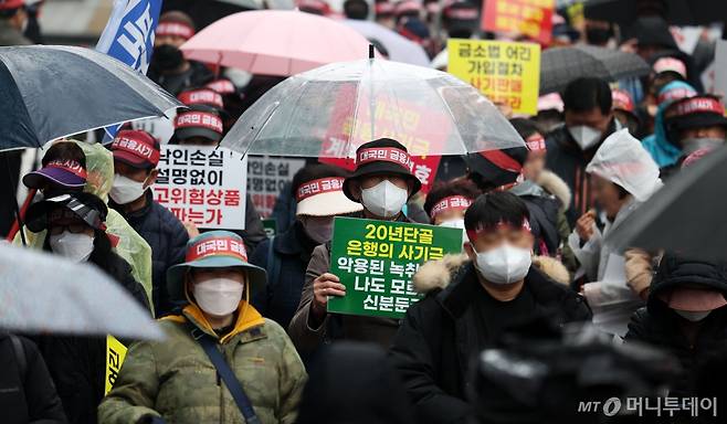 [서울=뉴시스] 김선웅 기자 = 홍콩ELS피해자들이 29일 서울 여의도의 한 은행 앞에서 집회를 열고 금융상품 손실 보상을 촉구하고 있다. 2024.03.29. mangusta@newsis.com /사진=김선웅