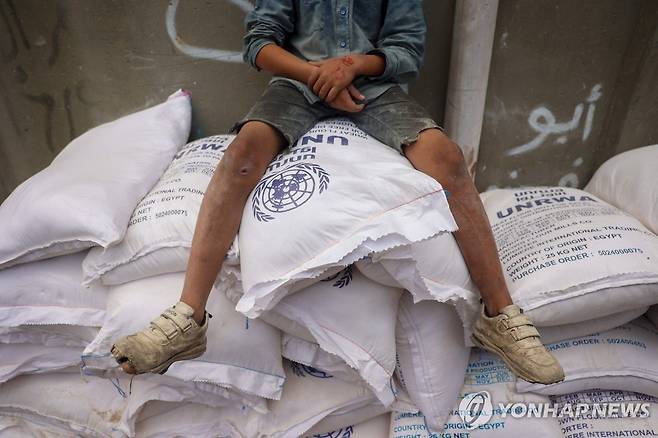 UNRWA 구호품 (AFP 연합뉴스) 4일(현지시간 팔레스타인 가자지구 데이르알발라의 한 구호품 배급소에 쌓인 밀가루 포대 위에 어린이가 앉아 있다. 2024.11.4 dk@yna.co.kr