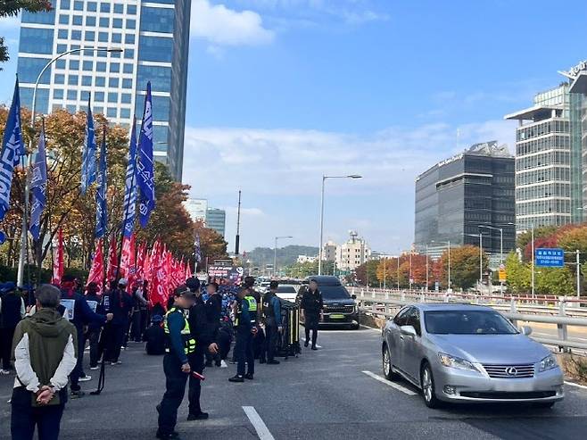 지난달 28일 현대트랜시스 노조원 등 1000여 명이 현대차·기아 양재사옥 앞 4개 차선 중 3개 차선을 막은 채 대규모 집회를 벌이면서 차량들이 남은 1개 차선으로 시위대 옆을 아슬아슬하게 지나가고 있다. (사진=독자 제공)