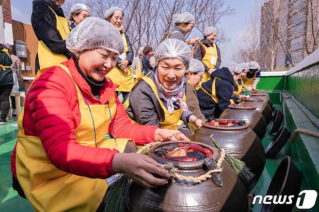 7일 서울 광진구청 옥상에서 열린 ‘전통식품 장 담그기 체험회’에서 주민들이 완성한 장을 바라보고 있다. (광진구청 제공) 2019.3.7/뉴스1