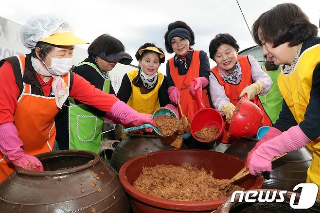 18일 오전 서울 서초구 대원농장에서 열린 '사랑의 된장·간장 담그기 행사'에서 주민과 자원봉사자들이 장을 담그고 있다. 포장된 간장과 된장은 연말을 맞아 저소득 독거 어르신과 소년소녀가장 300여 세대 및 복지시설에 전달된다. 2018.10.18/뉴스1 ⓒ News1 황기선 기자