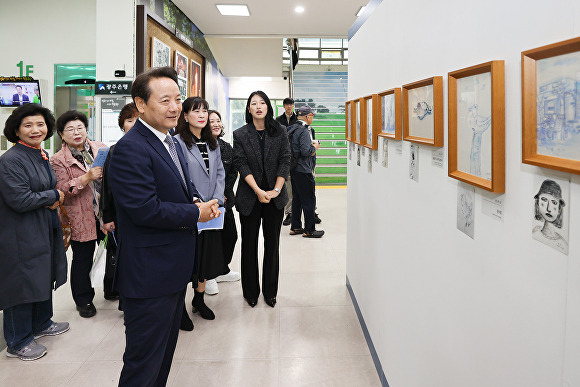 광주광역시 동구 관계자들이 '푸른 연필을 보았니?' 드로잉 작품전에 전시된 작품들을 감상하고 있다. [사진=광주 동구]