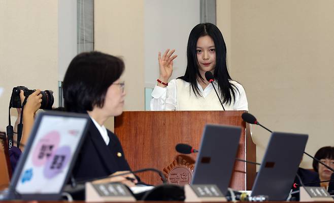 Hanni of girl group NewJeans testifies at the National Assembly's Environment and Labor Committee on Oct. 15 in western Seoul. [NEWS1]