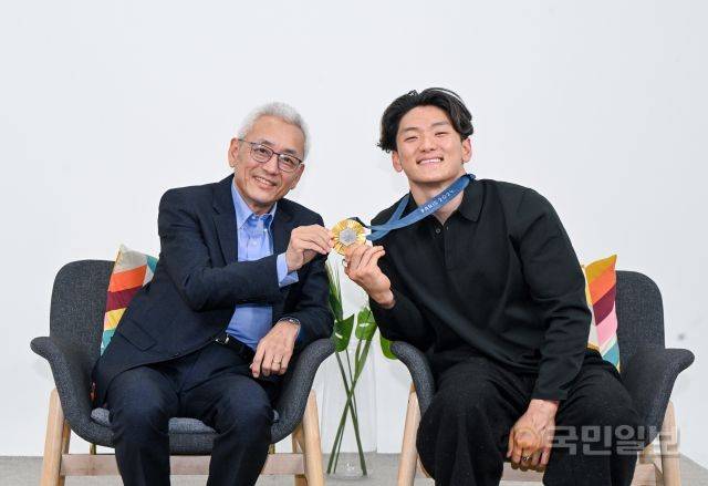 김병태(왼쪽) 목사와 아들인 '필 위자드' 필립 김 선수가 금메달을 들고 활짝 웃고 있다. 신석현 포토그래퍼