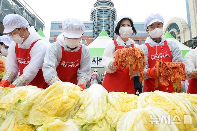 [울산=뉴시스] 배병수 기자 = 5일 오전 울산 남구 롯데백화점 광장에서 열린 '신격호 롯데 사랑드림 김장나눔'행사에서 장혜선(왼쪽 세번째) 롯데재단 이사장이 소외계층에 전달할 김장김치를 양념에 버무리고 있다. 2024.11.05.bbs@newsis.com.