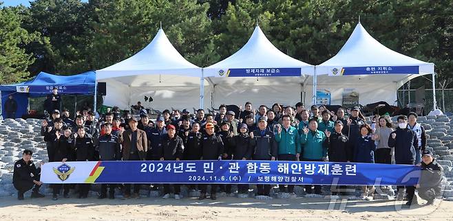 민·관 합동 해안방제 훈련 참가자들이 단체사진을 찍고 있다. (보령해경 제공)/뉴스1