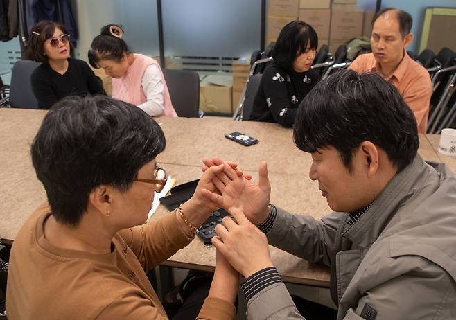헬렌켈러 센터에서 촉수화를 통해 소통하고 있는 시청각 장애인들. / 장련성 기자