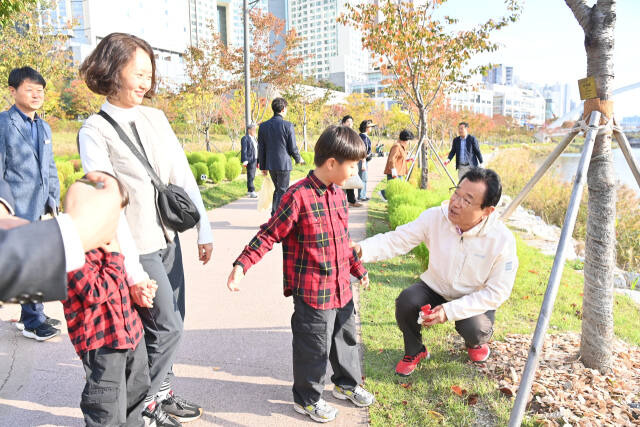 하남시 미사호수공원 벚꽃길에서 열린 ‘내 나무 비료 주기’ 행사에서 이현재 시장(오른쪽 첫번째)이 시민들과 대화를 나누고 있다. 하남시 제공