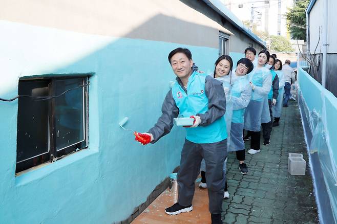 최덕근 건보공단 본부장과 직원들이 5일 에바다드림홈에서 담장 도색 봉사활동을 하면서 기념촬영을 하고 있다./사진=건보공단