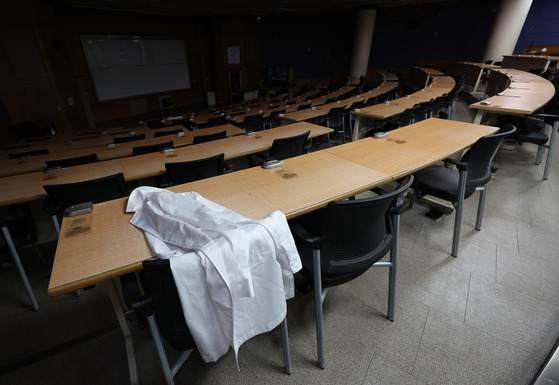 A medical gown is placed on a desk inside a lecture hall of medical school's building in Daegu in last month. [YONHAP]