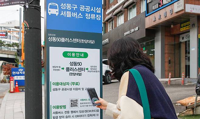 11월 1일 서울 성동구 한양대 앞 정류장에서 주민 이현정(47)씨가 성공버스에 오르기 전 QR코드(탑승권)를 내려받고 있다.