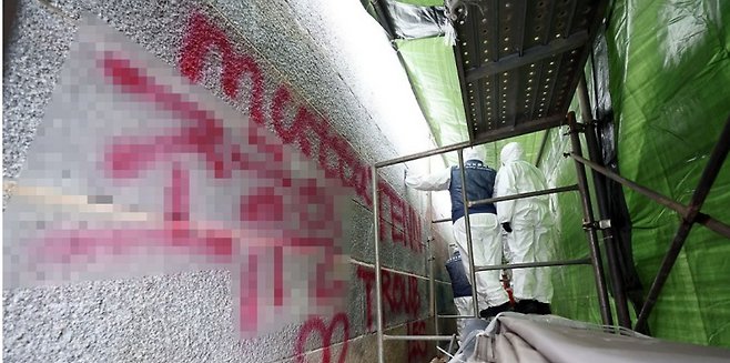 작년 12월 서울 종로구 경복궁 영추문에서 문화재청 관계자들이 스프레이 낙서로 훼손된 담벼락 복구 작업을 하고 있다. 연합뉴스 자료사진