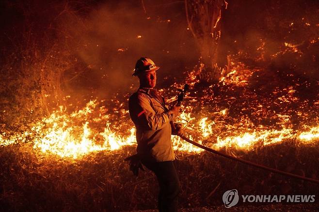 6일(현지시간) 캘리포니아 벤투라 카운티 샌타폴라에서 산불과 싸우는 소방관 [AP=연합뉴스. 재판매 및 DB 금지]