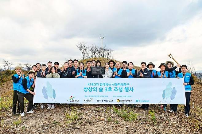 KT&G 임직원 봉사단이 경북 울진군 북면 해안생태 탐방로 인근에 '상상의 숲'을 조성하기 위해 나무를 식재한 뒤 기념촬영하고 있다. KT&G 제공