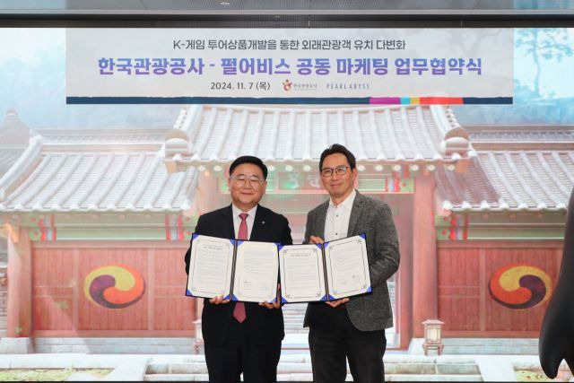 이학주(왼쪽) 한국관광공사 국제관광본부장이 7일 펄어비스 본사에서 김경만 펄어비스 서비스사업부분 이사와 함께 게임 투어 상품 개발을 위한 공동 마케팅 업무협약을 체결한 뒤 협약서를 들어보이고 있다. [사진제공=한국관광공사]