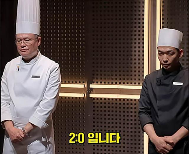 '흑백요리사'에서 백수저 여경래(왼쪽) 셰프가 요리 대결을 펼친 흑수저 '철가방요리사'와 심사 결과를 전달받고 있다. 넷플릭스 흑백요리사 유튜브 캡처