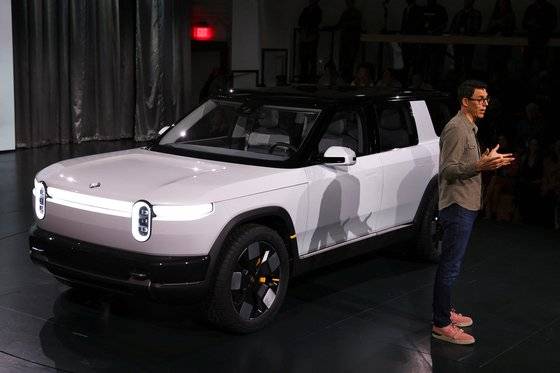 지난 3월 7일 미국 캘리포니아주 라구나비치에서 열린 리비안 R2 SUV 공개 행사에서 리비안 CEO RJ 스카링이 모델을 소개하고 있다. 로이터=연합뉴스