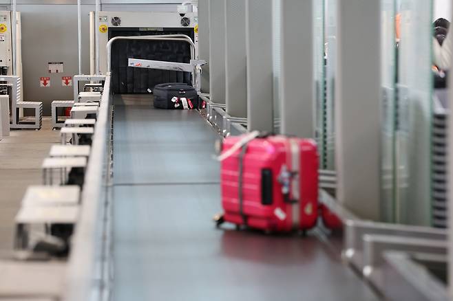 Pieces of checked luggage are carried by a conveyor belt on the departure floor at Terminal 1 at Incheon International Airport in May. [YONHAP]