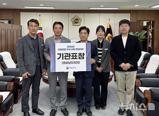 [창원=뉴시스]경상남도의회 최학범(왼쪽 두 번째) 의장이 8일 의장 집무실에서 '2024년 지방의회 우수사례 경진대회'에서 의회 혁신 분야 우수성을 인정받아 행정안전부장관 표창을 수상한 것에 대한 기념촬영을 하고 있다.(사진=경남도의회 제공)2024.11.08. photo@newsis.com