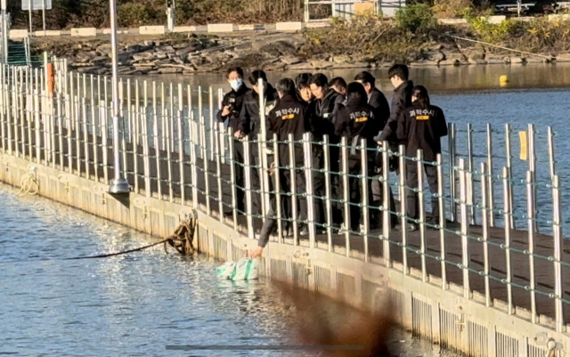 6일 진행된 현장 검증에서 양씨가 다리 위에서 훼손된 시신이 담긴 봉투를 강 아래로 떨어뜨리는 범행 당시 상황을 재연하는 모습. 연합뉴스