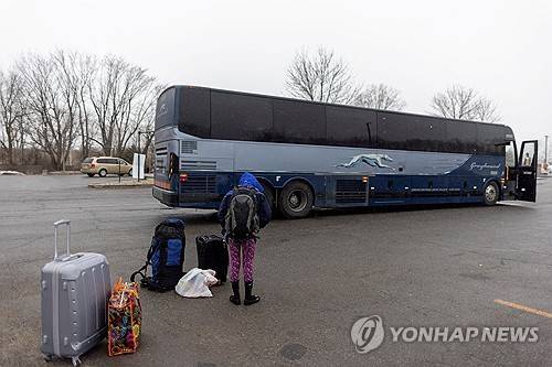 록섬 로드 거쳐 캐나다 입국하려는 청년 (미국 뉴욕주 플래츠버그 로이터=연합뉴스) 2023년 3월 25일 가족과 함께 캐나다로 입국하려는 한 청년이 버스에서 하차해 택시를 기다리고 있다. (REUTERS/Carlos Osorio/ 자료사진) 2024.11.9.