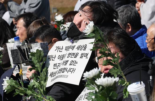 지난 2월26일 오전 서울 용산구 대통령실 앞에서 송파 세 모녀 10주기 추모제가 열려 참가자들이 흰 국화를 들고 있다. 2014년 2월 26일 서울 송파구의 반지하방에서 생활고에 시달리던 세 모녀가 마지막 월세와 공과금, `죄송하다\'는 편지를 남긴 채 세상을 등져 당시 사회안전망의 한계를 드러낸 대표적 사건으로 주목받은 바 있다. 백소아 기자 thanks@hani.co.kr