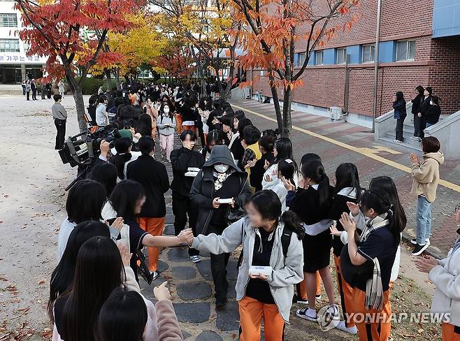 '수능 대박나세요' (울산=연합뉴스) 김용태 기자 = 2025학년도 대학수학능력시험 예비소집일인 13일 오전 울산시 중구 울산중앙여고에서 3학년 학생들이 1, 2학년 학생들의 응원을 받으며 학교를 나서고 있다. 2024.11.13 yongtae@yna.co.kr