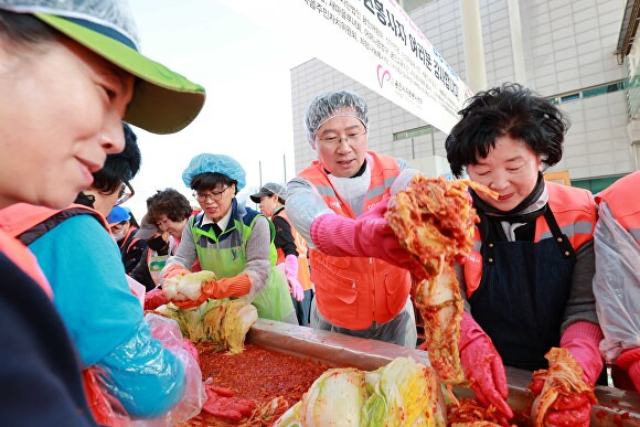 이상일 용인특례시장이 지난 13일 시청 광장에서 열린 김장대첩 행사에서 봉사자들과 김장 김치를 버무리고 있다. [사진=용인특례시]