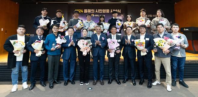 S-Oil CEO Anwar A. AL-Hejazi, sixth from left, and S-Oil President Ryu Yeol, fourth from right in the front row, pose with 17 citizen heroes at a ceremony at the oil refiner’s headquarters in Mapo District, western Seoul, on Thursday.[S-OIL]