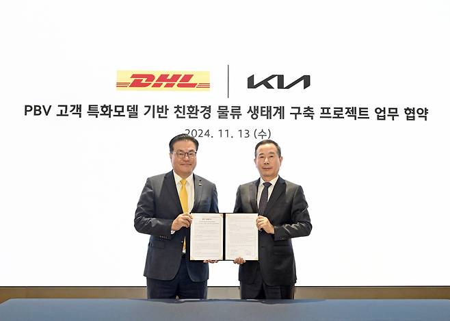 한지헌(왼쪽) DHL 코리아 대표와 정원정 기아 국내사업본부장(부사장)이 13일 진행된 업무협약식에서 기념 촬영을 하고 있다. [기아 제공]