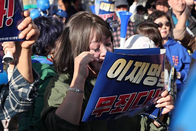 이재명 더불어민주당 대표의 '공직선거법 위반' 1심 선고 공판에서 징역 1년에 집행유예 2년을 선고받은 15일 서울 서초구 서울중앙지방법원 앞에서 한 지지자가 눈물을 닦고 있다. /뉴스1