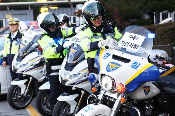 대학수학능력시험을 사흘 앞둔 11일 오전 경기도 수원시 영통구 수원남부경찰서에서 경찰관들이 수능 특별 교통관리에 사용될 경찰 오토바이와 순찰차에 안내문을 부착하고 있다. 연합뉴스