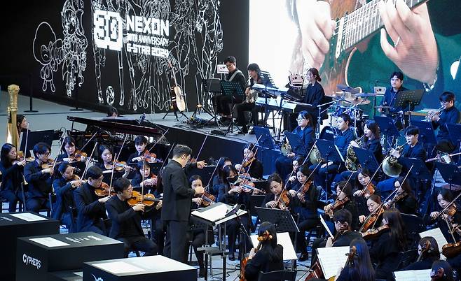 '30주년' 넥슨, 기념 오케스트라 공연     (부산=연합뉴스) 김주환 기자 = 넥슨이 지스타 2024 개막 3일차를 맞은 16일 벡스코(BEXCO) 제1전시장 부스에서 아르츠심포니오케스트라와 함께 '넥슨 30주년 오케스트라' 공연을 열고 있다. 2024.11.16 jujuk@yna.co.kr